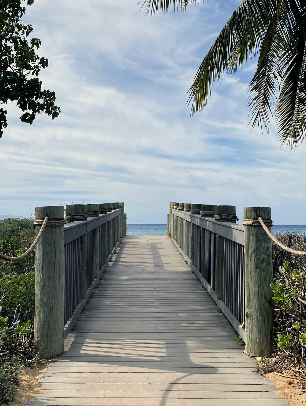 brown wooden dock on sea under blue sky during daytime