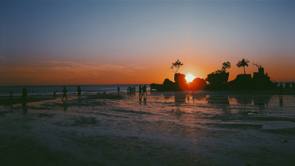 silhouette of people on beach during sunset