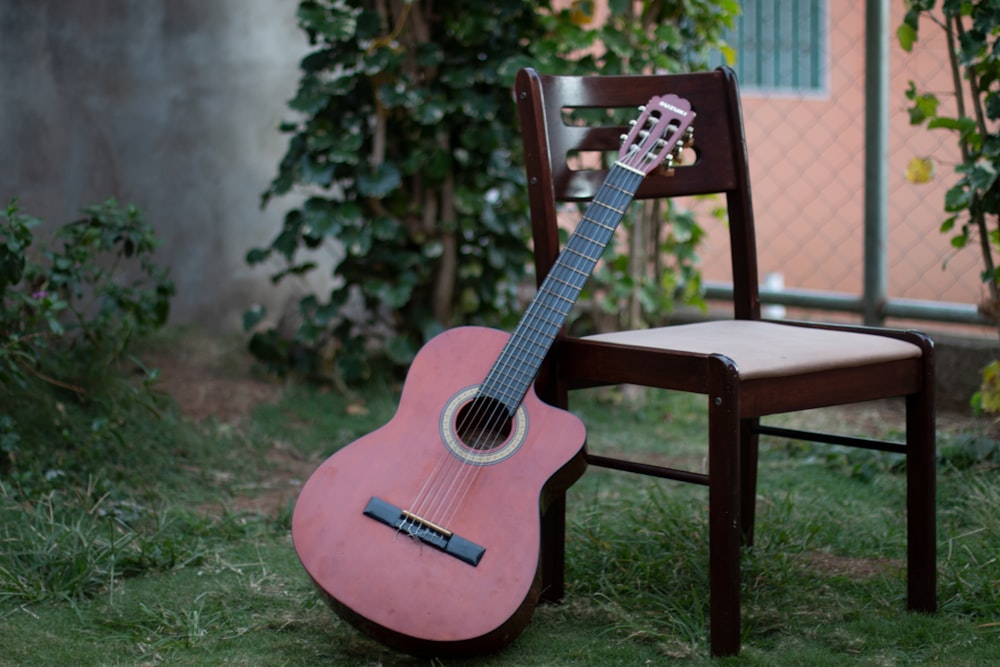 red acoustic guitar on brown wooden table