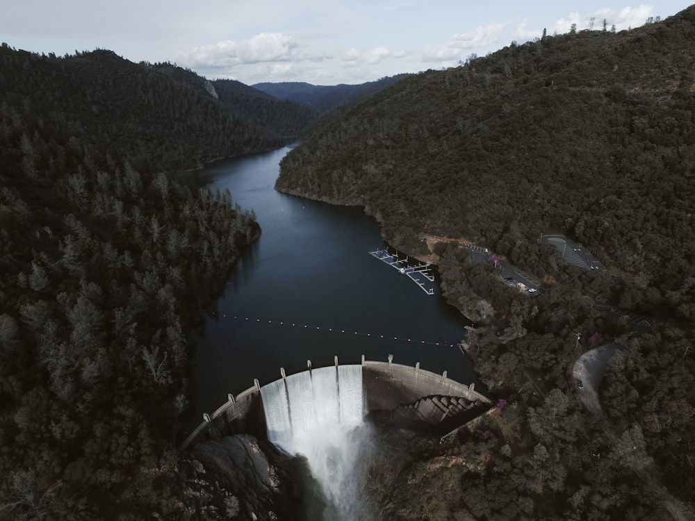 water falls on green mountain during daytime