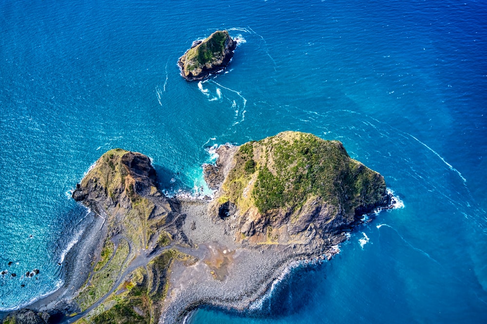 green and brown rock formation on blue sea water during daytime