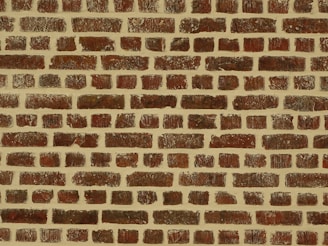 A pattern of evenly spaced reddish-brown bricks arranged with mortar, creating a textured and uniform appearance.