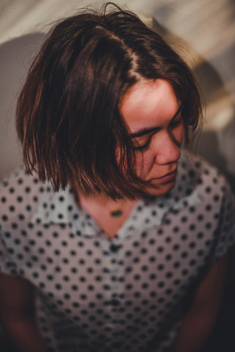 woman in white and black polka dot shirt wearing black framed eyeglasses