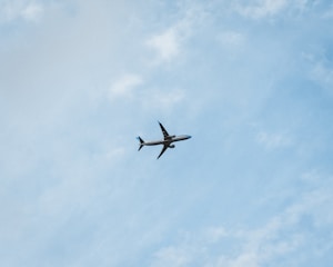 A Boeing aircraft soaring through a clear blue sky, symbolizing travel and adventure.