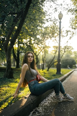 photography poses for women,how to photograph екатерина; woman in blue denim jeans sitting on concrete pathway during daytime
