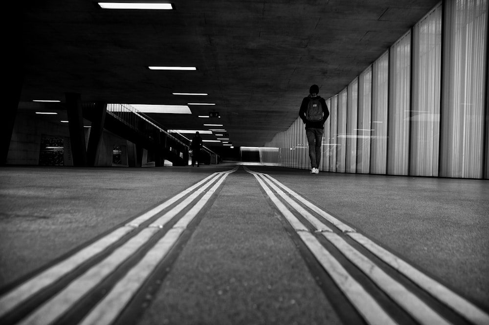 man in black jacket walking on sidewalk