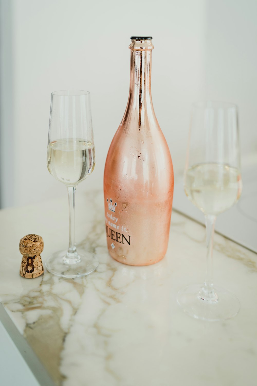 pink glass bottle beside clear glass cup