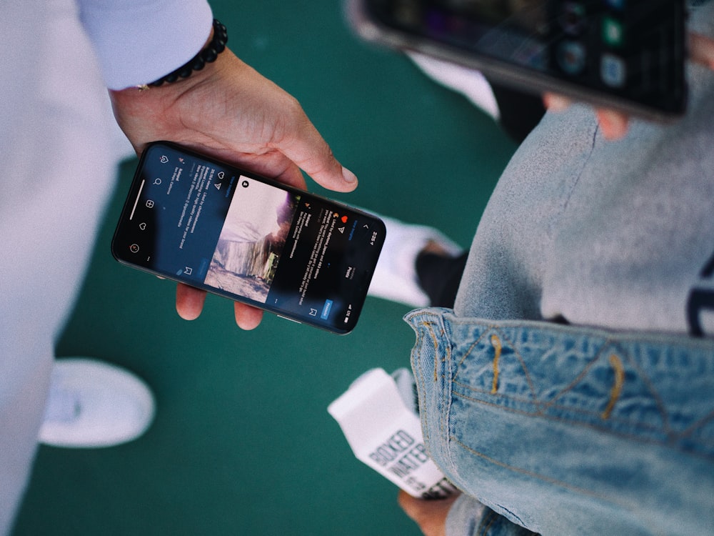 person holding black iphone 4