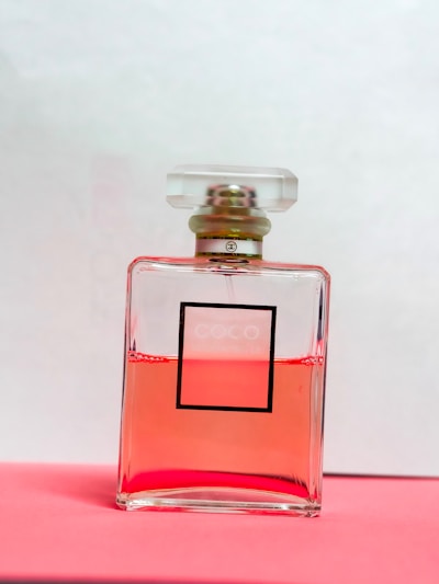 Elegant perfume bottle with soft pink hues on a minimalist white background