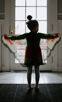 girl in black and red plaid jacket standing on white floor tiles