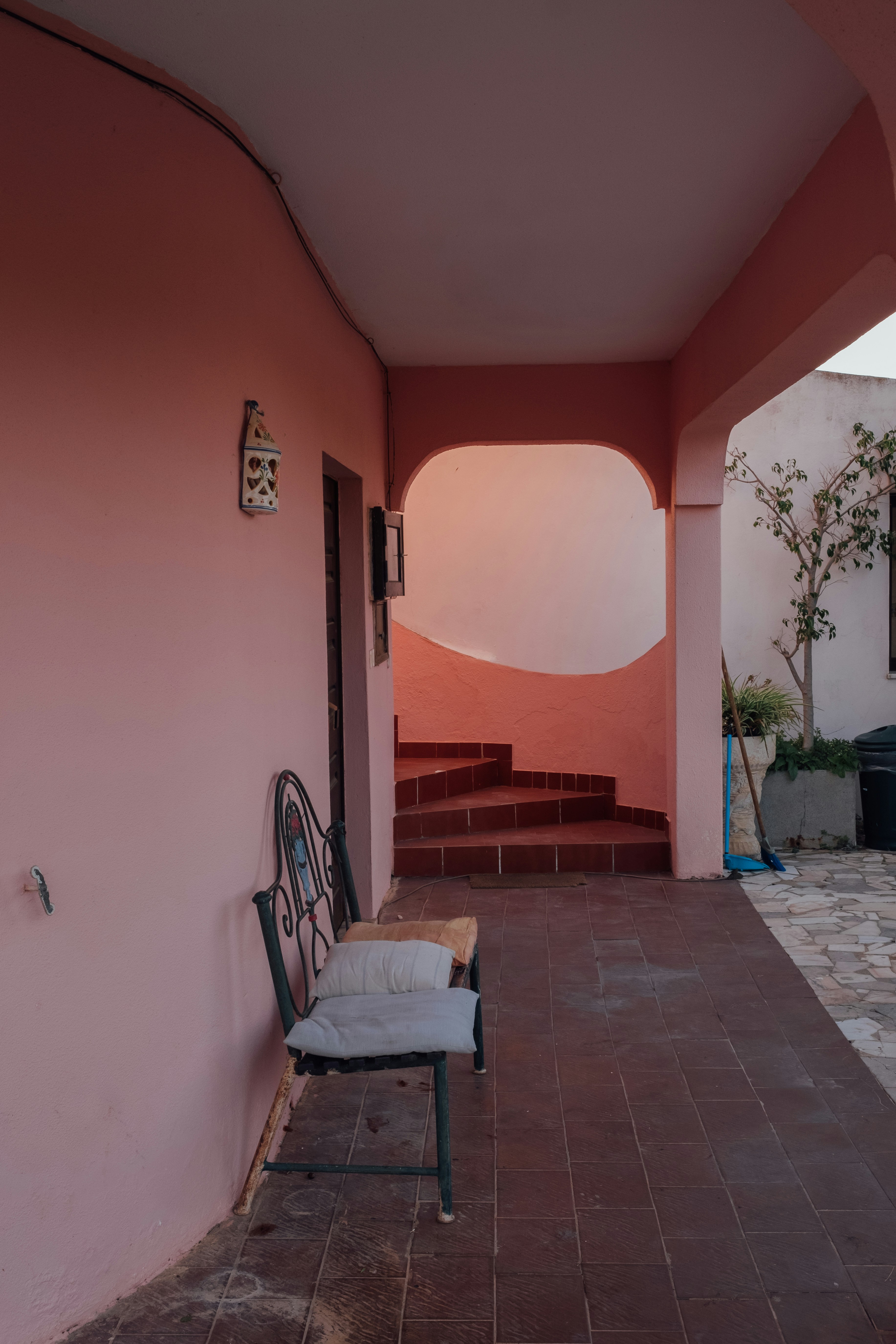 brown wooden bench beside brown concrete wall