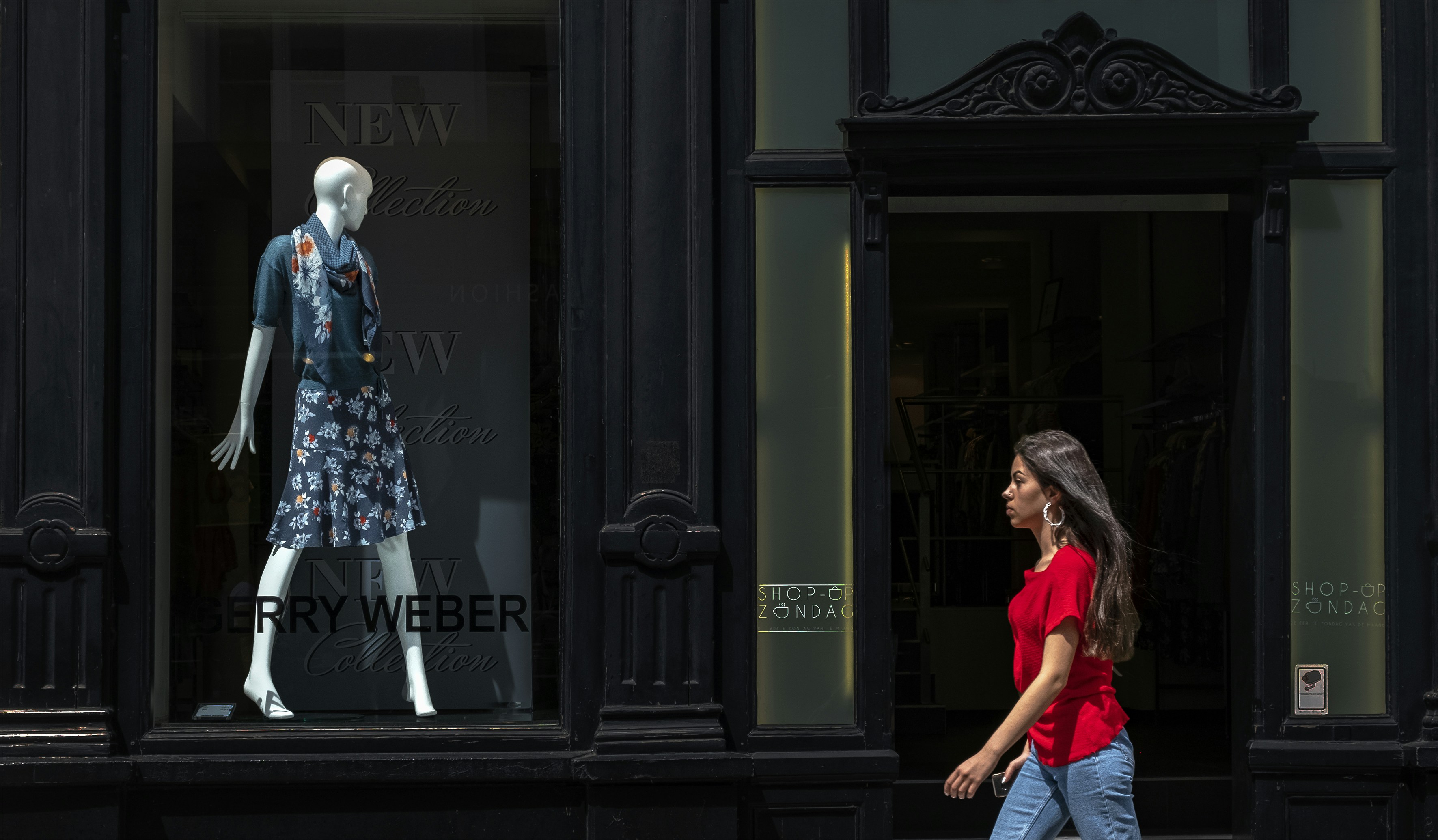 woman in blue and white floral dress standing in front of black wooden door