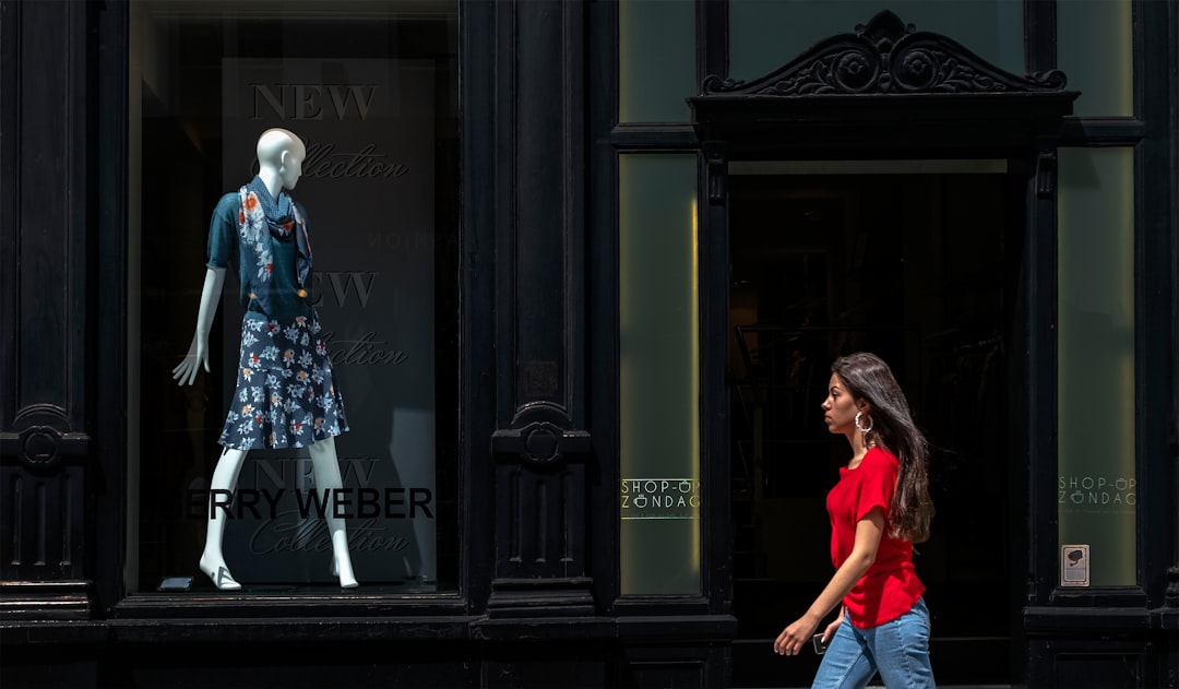 woman in blue and white floral dress standing in front of black wooden door