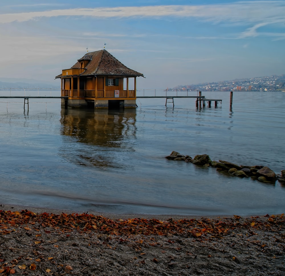 casa de madeira marrom no corpo de água durante o dia