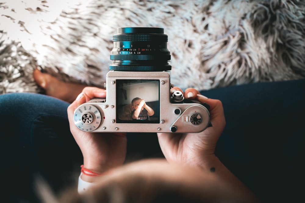 person holding silver and black camera lens