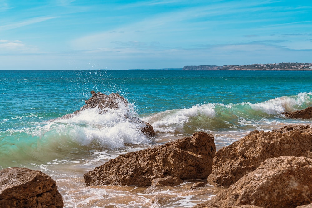 brown rock formation near sea waves during daytime