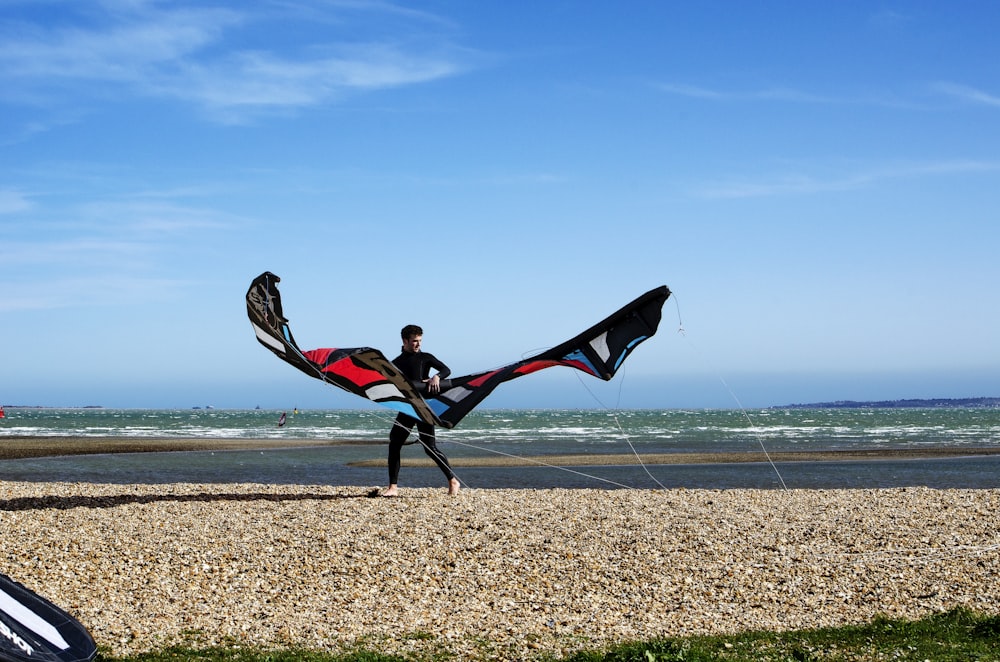 2 women in red and black dress running on brown sand near body of water during