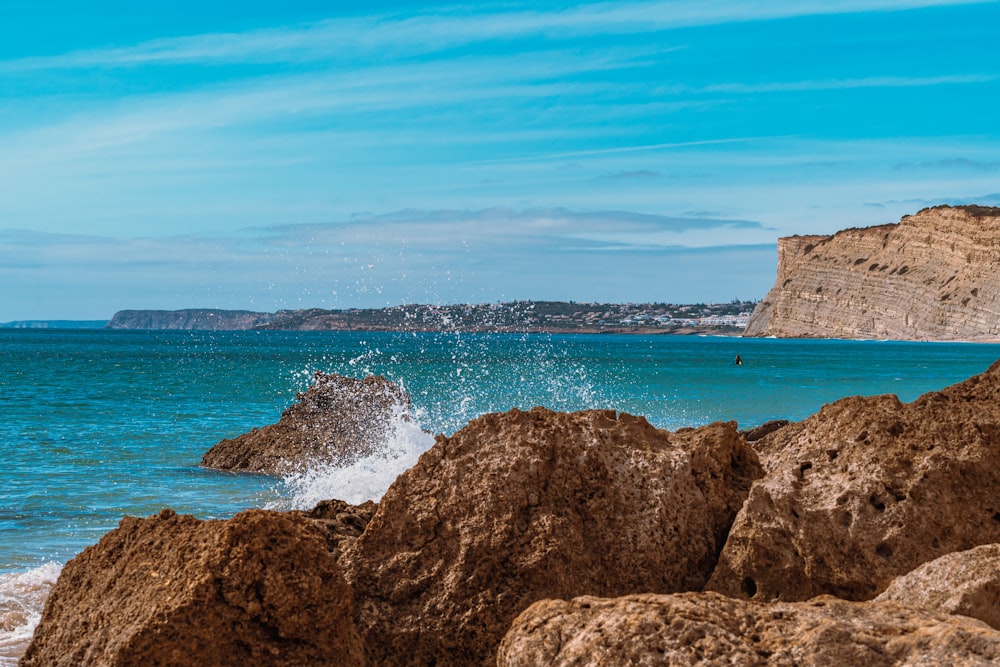 brown rock formation on sea during daytime