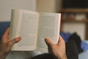 Happy reader lounging with a book and headphones, radiating vibrant energy.