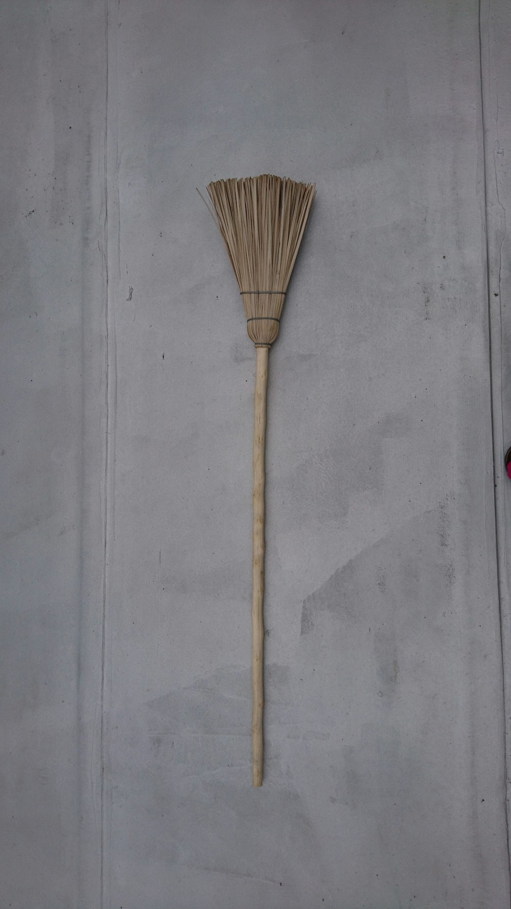 brown broom on gray concrete floor