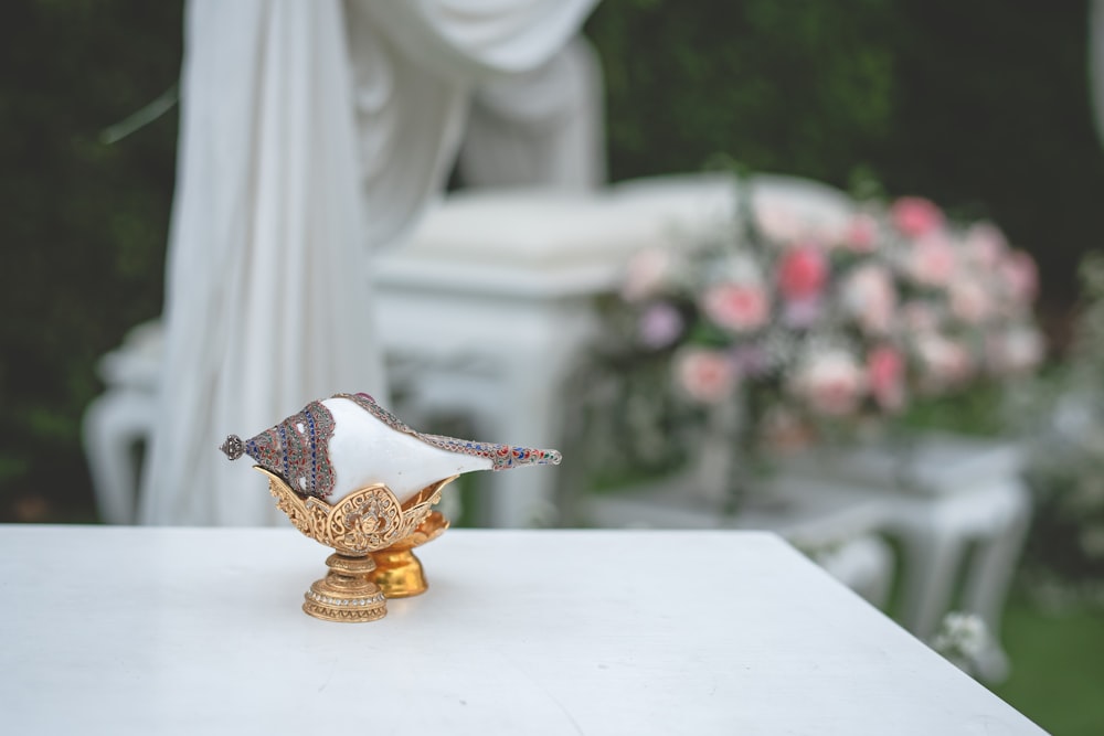 gold and red floral vase on white table