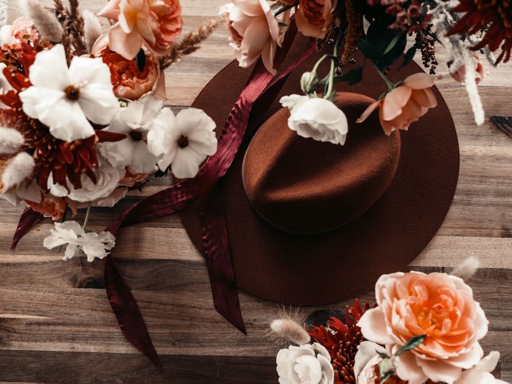 brown fedora hat beside white and pink flowers