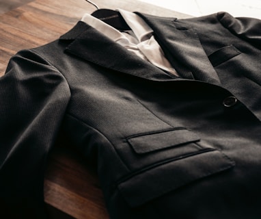 black suit jacket on brown wooden table