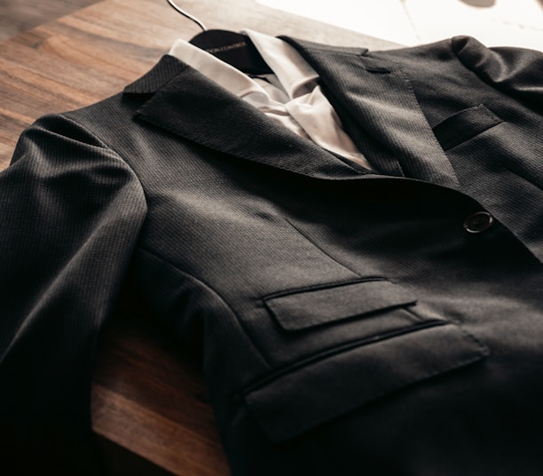 black suit jacket on brown wooden table