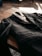 A close-up of a neatly folded tailored suit on a wooden table.