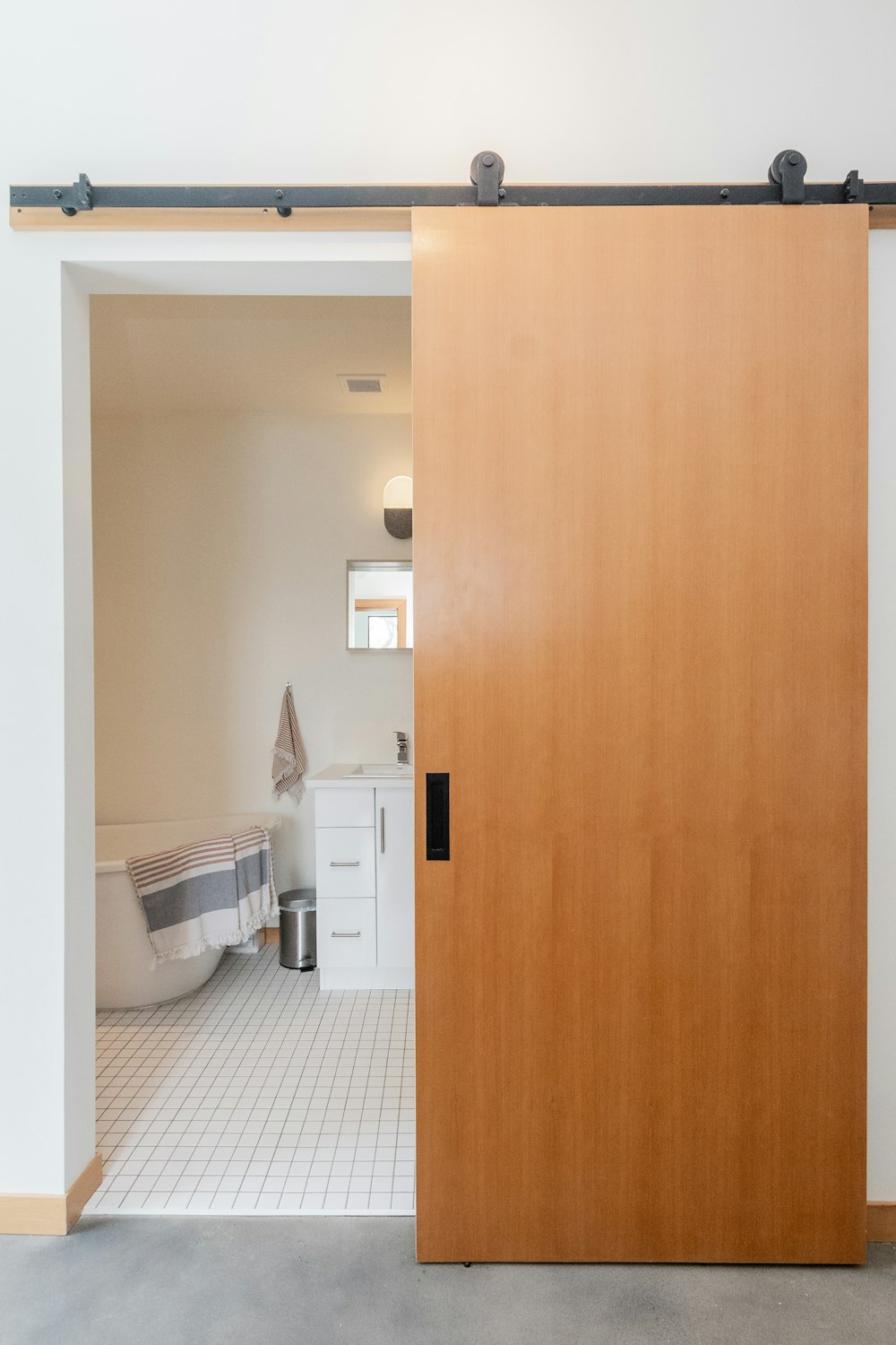 brown wooden door near white ceramic toilet bowl