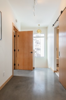 brown wooden door near white wall
