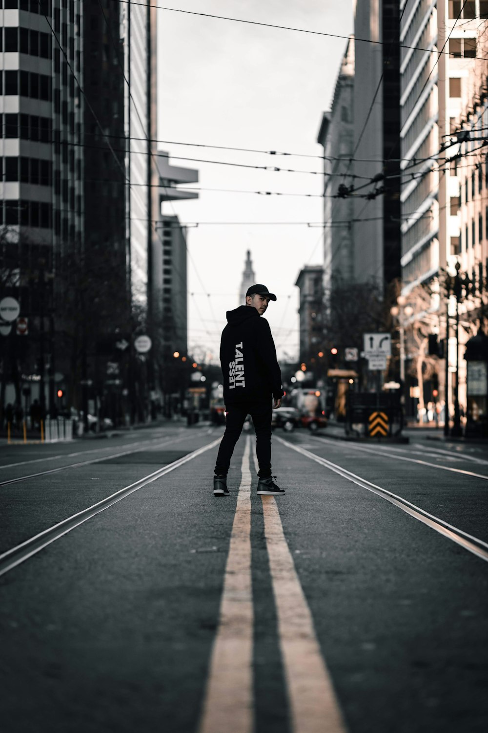 man in black jacket and black pants walking on pedestrian lane during daytime