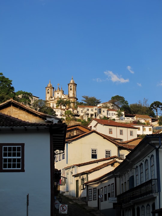 white and brown concrete buildings under blue sky during daytime in Ouro Preto Brasil