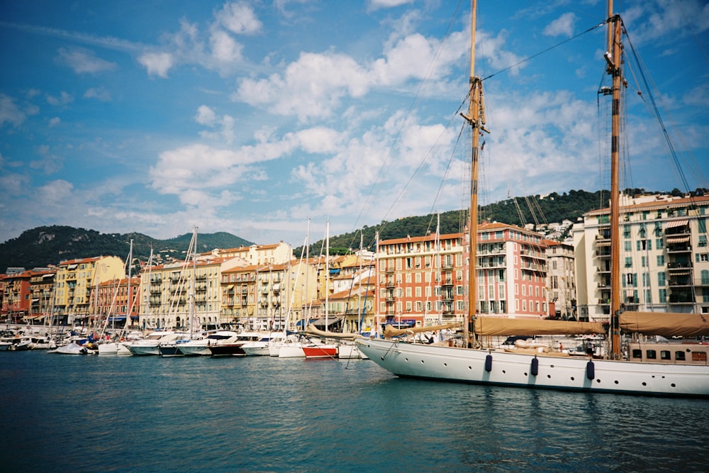 white and brown boat on water near city buildings during daytime