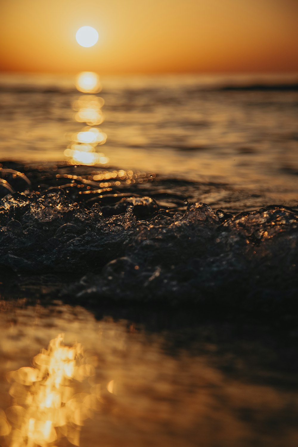 Chapoteo de agua en la orilla durante la puesta de sol