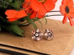 Elegant gemstone earrings displayed on a rustic wooden surface with natural light highlighting their colors.