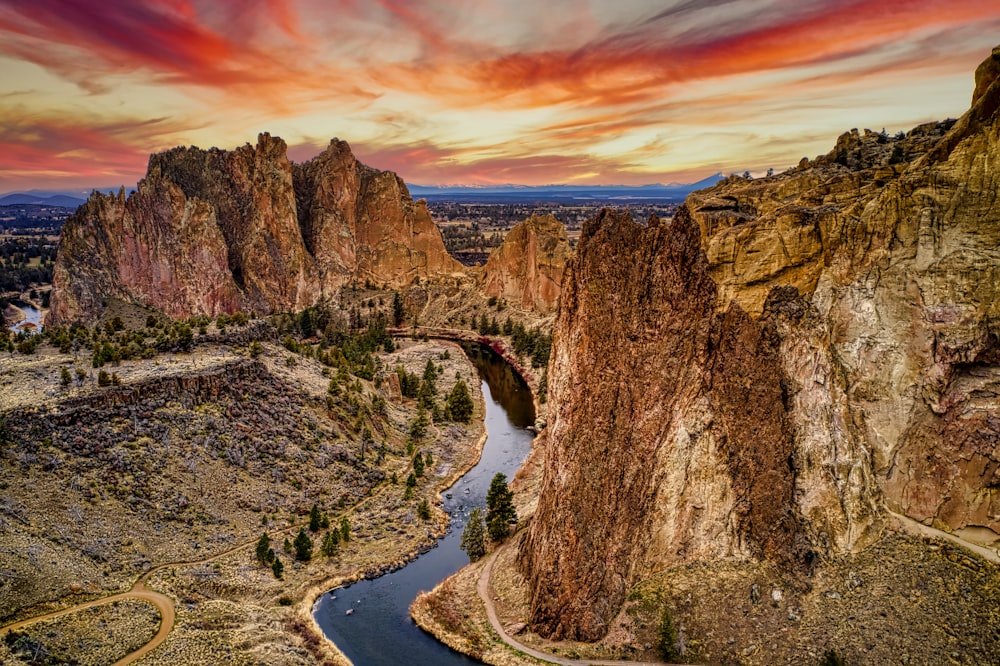 river between brown rocky mountains during sunset