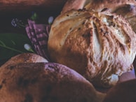 Golden-brown homemade bread fresh out of the oven, resting on a linen cloth.