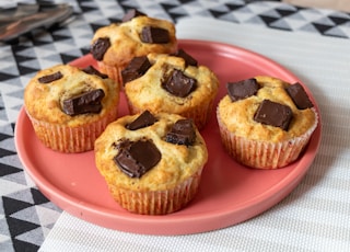 a pink plate topped with muffins on top of a table