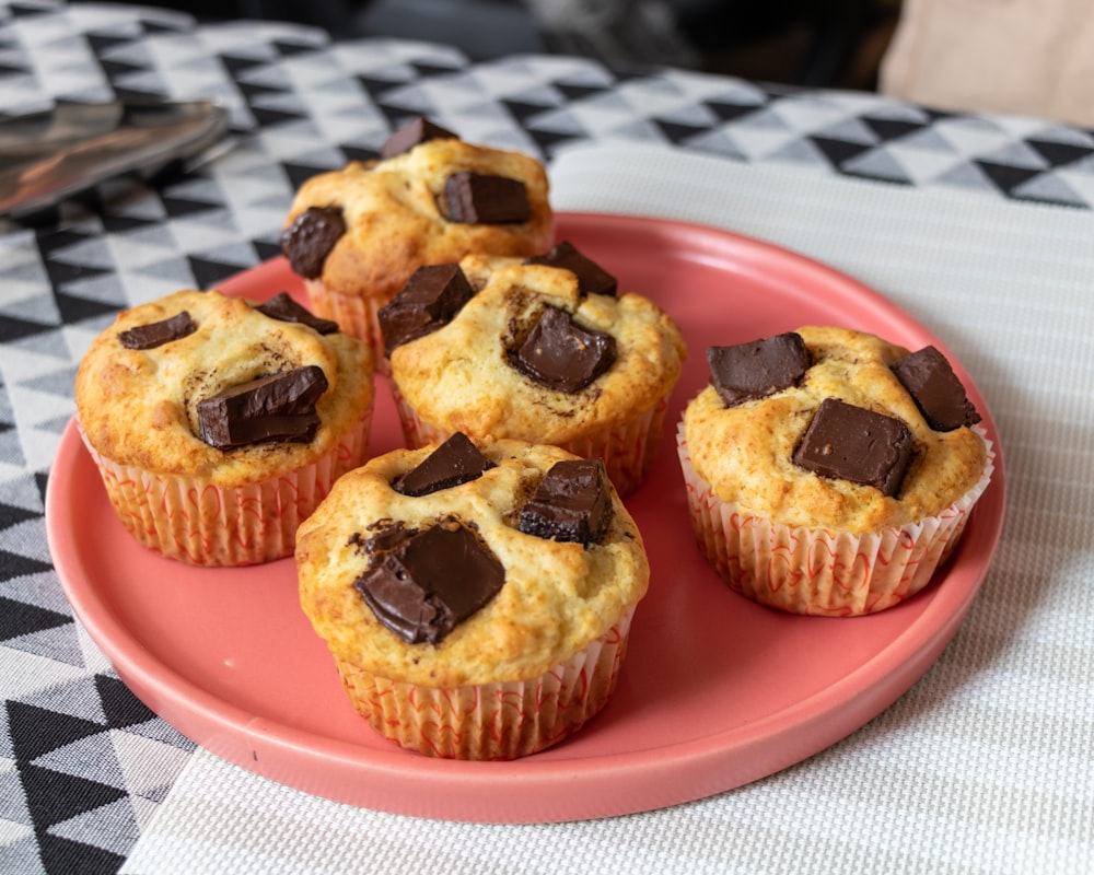 a pink plate topped with muffins on top of a table