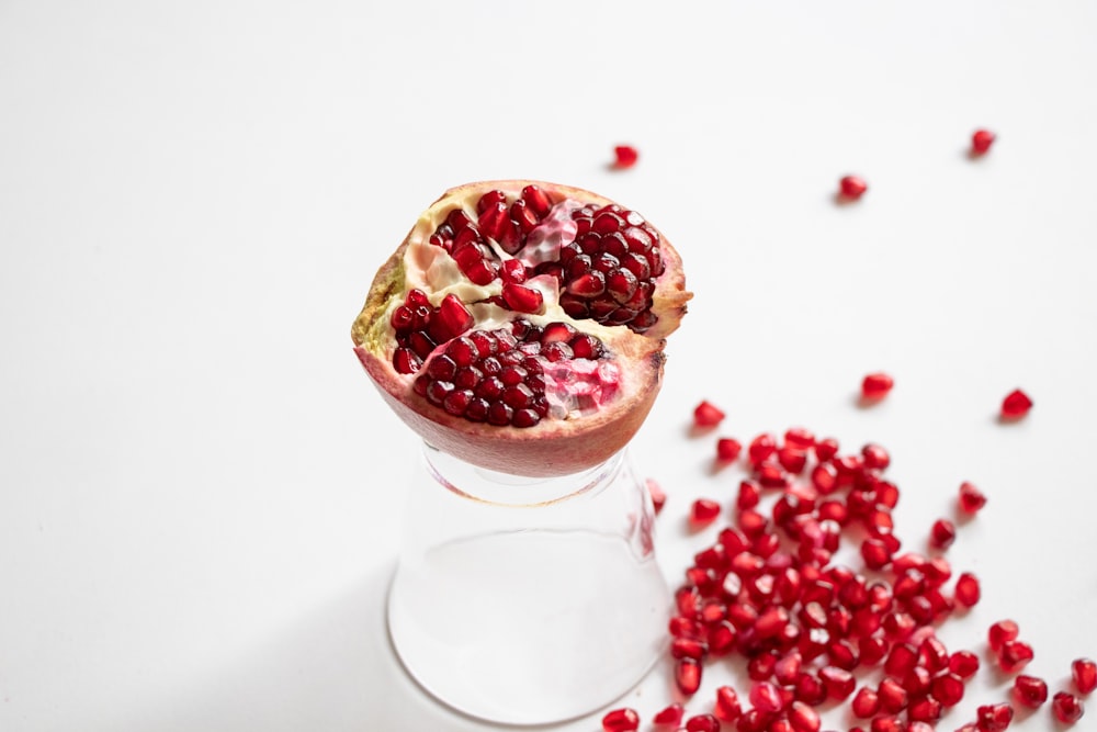 a pomegranate sitting on top of a glass of water