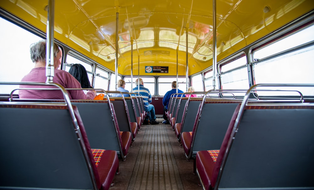 Menschen, die auf rotem und blauem Bussitz sitzen