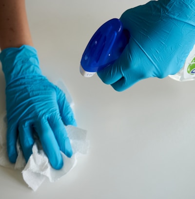 person in blue gloves holding white textile