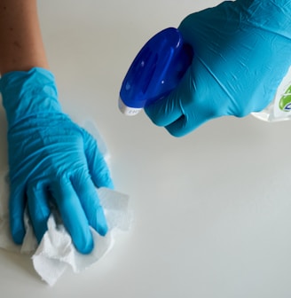 person in blue gloves holding white textile