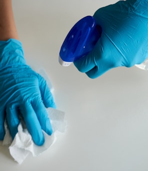 person in blue gloves holding white textile