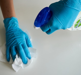 person in blue gloves holding white textile