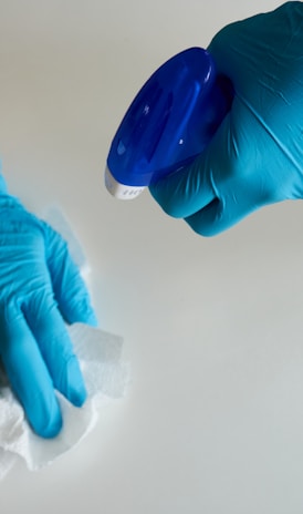 una persona con guantes azules limpiando una superficie