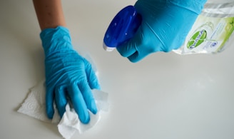 una persona con guantes azules limpiando una superficie