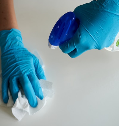 person in blue gloves holding white textile