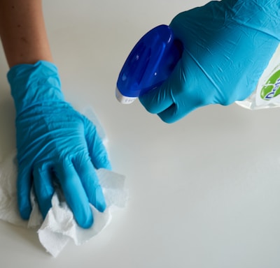 person in blue gloves holding white textile